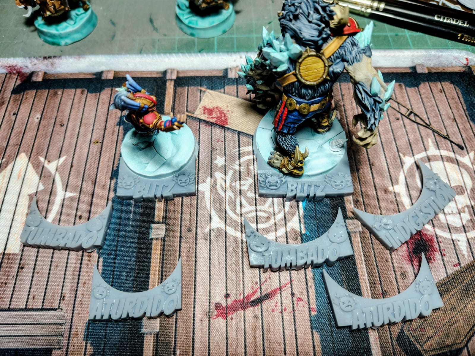 Marcadores de estado junto a miniaturas sobre el campo